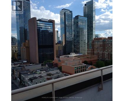 A cityscape with tall buildings and a bridge in the foreground.