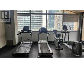A gym with treadmills, exercise bikes, and a large window.