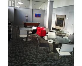 A room with a pool table and chairs.