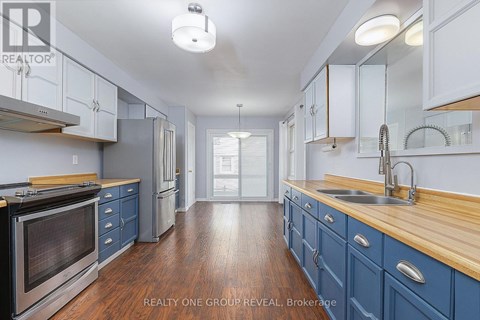 A kitchen with blue cabinets and a wooden counter top.