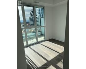 A room with a view of a cityscape through large windows.
