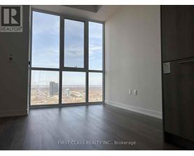 A room with a view of the city through large windows.