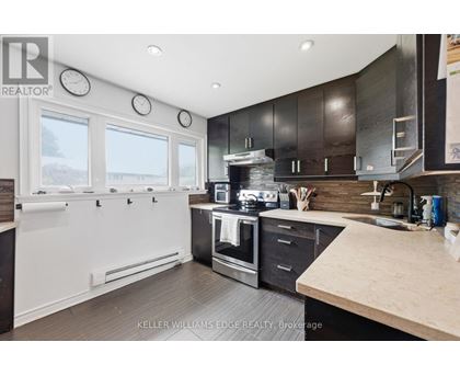 A modern kitchen with a stainless steel oven and black cabinets.