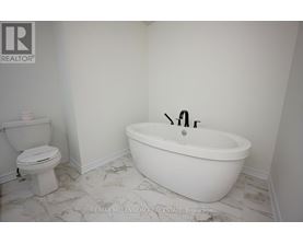 A white bathroom with a toilet and a bathtub.