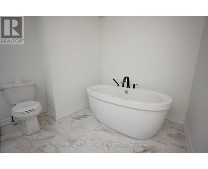 A white bathroom with a toilet and a bathtub.