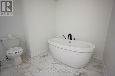 A white bathroom with a toilet and a bathtub.