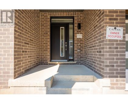 A sign on a brick wall says "CAYAN OWNER OCCUPIED".
