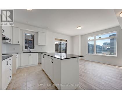A kitchen with white cabinets and a black countertop.