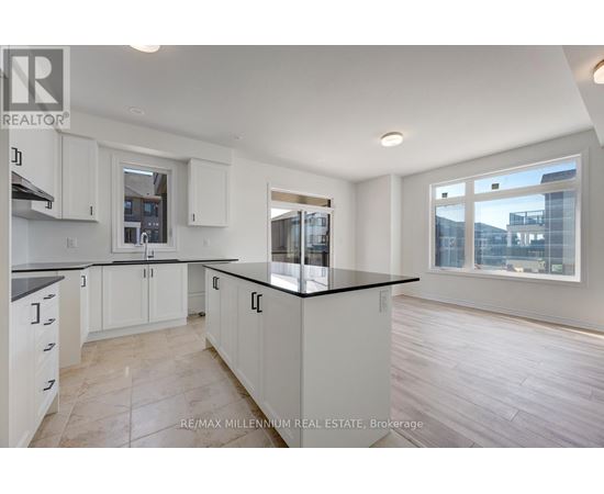 A kitchen with white cabinets and a black countertop.