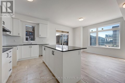 A kitchen with white cabinets and a black countertop.