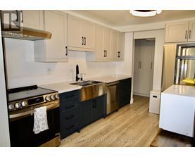 A kitchen with black cabinets and a white stove top oven.