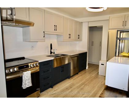 A kitchen with black cabinets and a white stove top oven.