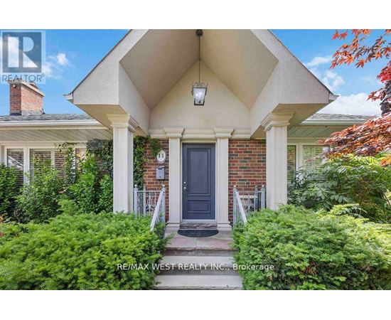 A house with a blue door and a sign that says RE/MAX West Realty Inc. Brokerage.