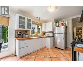 A kitchen with white cabinets and a refrigerator.