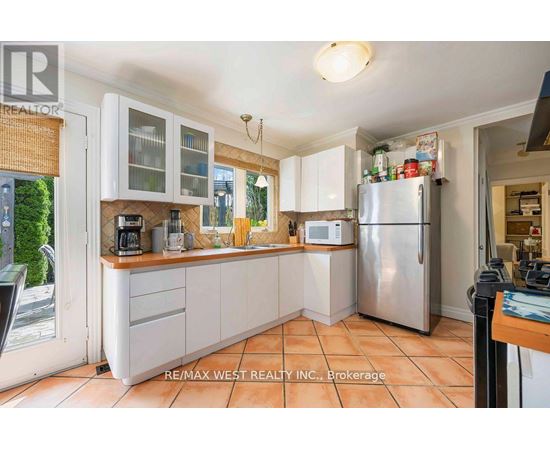 A kitchen with white cabinets and a refrigerator.