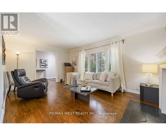 A living room with a black leather chair and a white sofa.