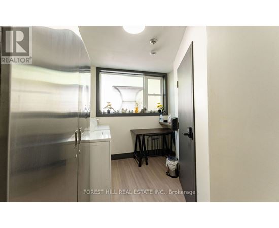 A small kitchen with a refrigerator, sink, and a window.