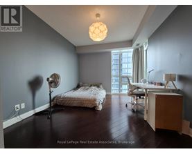 A bedroom with a bed, desk, and chair.