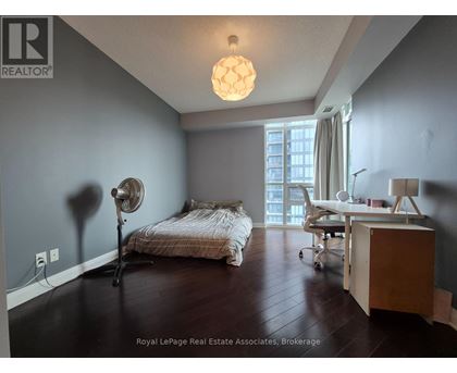 A bedroom with a bed, desk, and chair.