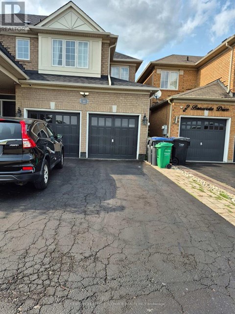 A black SUV is parked in a driveway in front of a house.