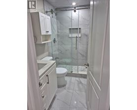 A white bathroom with a glass shower stall.