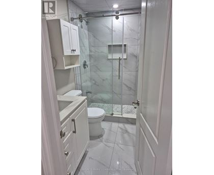 A white bathroom with a glass shower stall.