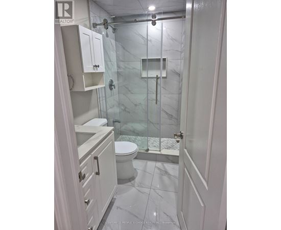 A white bathroom with a glass shower stall.
