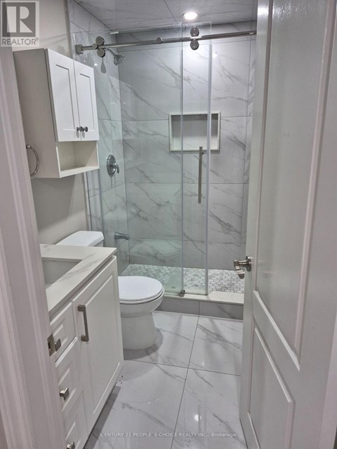 A white bathroom with a glass shower stall.