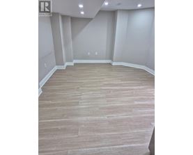 A room with wooden flooring and white walls.