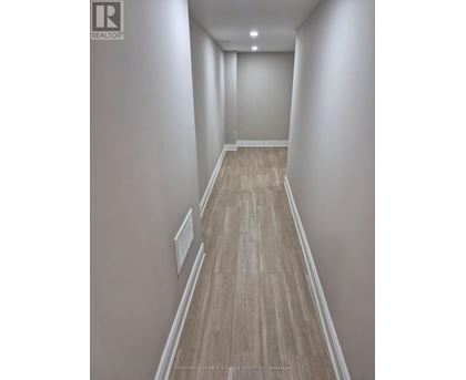 A room with wooden flooring and white walls.