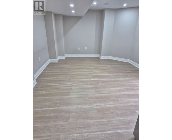 A room with wooden flooring and white walls.