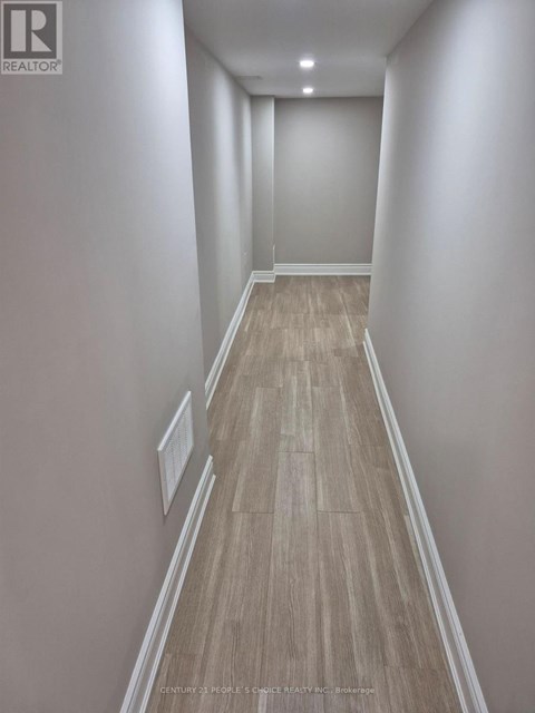 A room with wooden flooring and white walls.