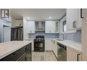 A kitchen with white cabinets and a black stove top oven.