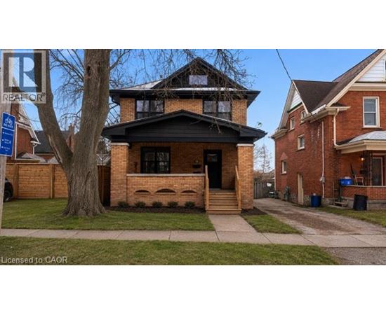 A brick house with a black front door and steps.