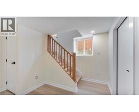 A white interior with a wooden staircase and a window.