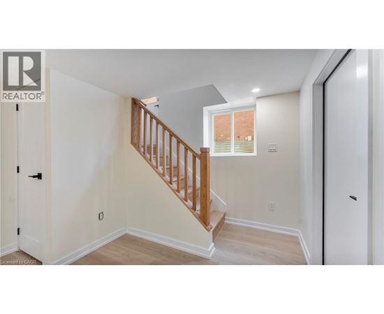 A white interior with a wooden staircase and a window.
