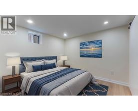 A bedroom with a bed, two lamps, and a painting on the wall.