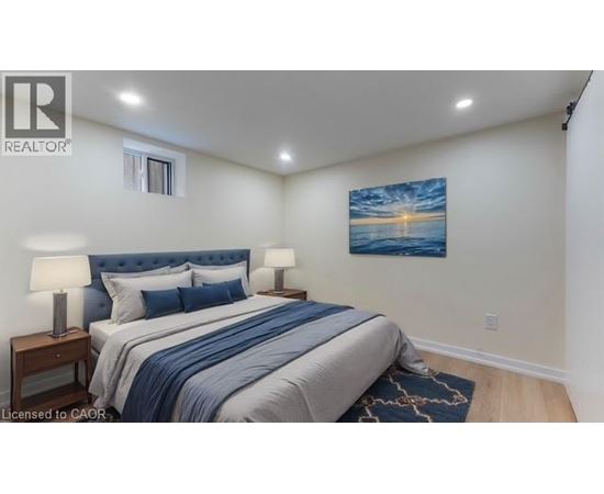 A bedroom with a bed, two lamps, and a painting on the wall.