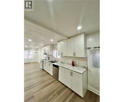 A kitchen with white cabinets and a marble countertop.