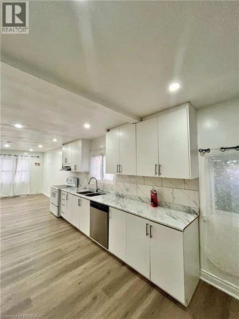 A kitchen with white cabinets and a marble countertop.