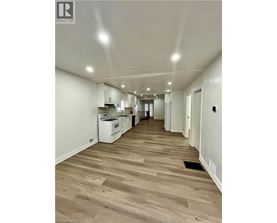 A long hallway with a kitchen area at the end.