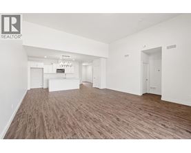 A spacious room with wooden flooring and white walls.