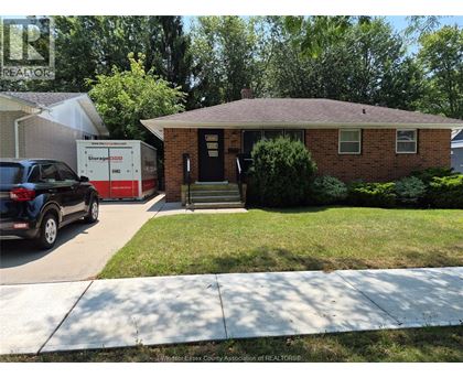 A small brick house with a black door and a small porch.
