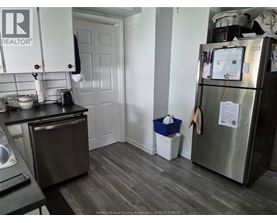 A kitchen with a refrigerator, toaster, and a dishwasher.