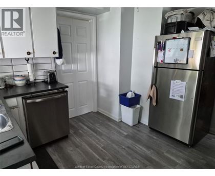 A kitchen with a refrigerator, toaster, and a dishwasher.