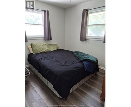 A bedroom with a bed, pillow, and blanket.