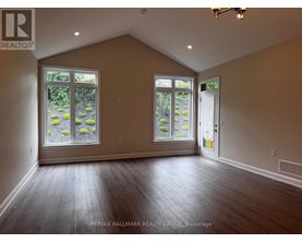 A room with a large window and a door is empty and waiting to be furnished.