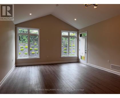A room with a large window and a door is empty and waiting to be furnished.