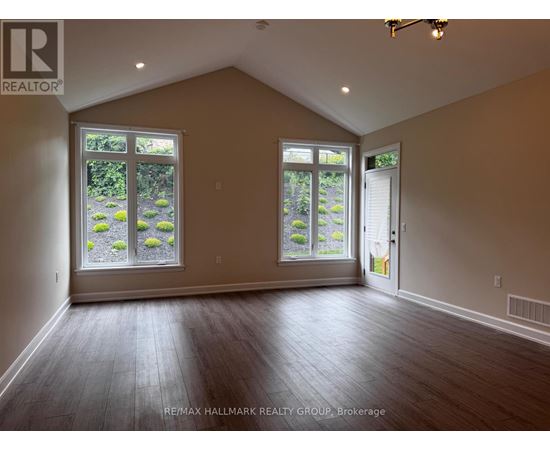 A room with a large window and a door is empty and waiting to be furnished.