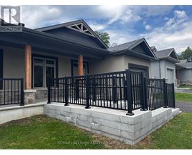 A house with a black fence and a grey roof.